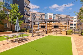A small grassy area with a picnic table and a shade umbrella.